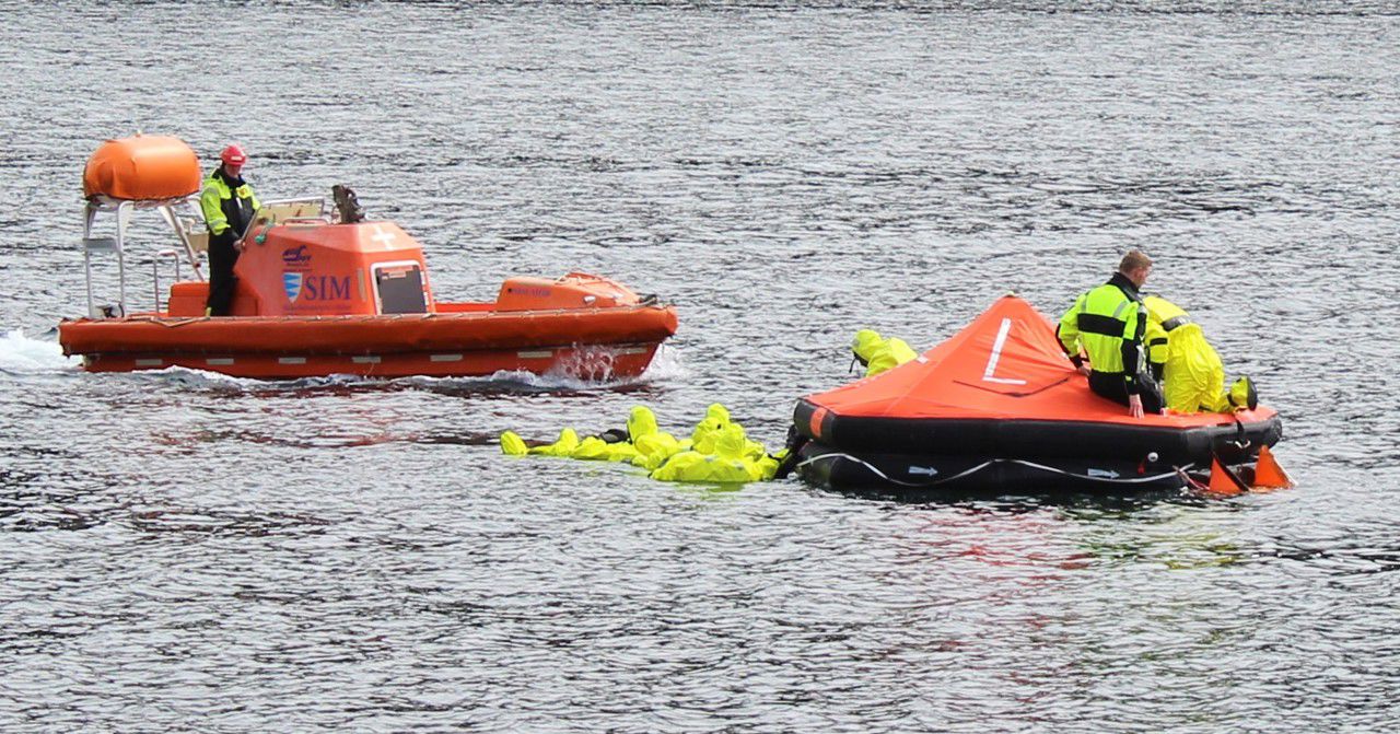 Personer som øver på å komme opp i redningsflåte